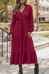 Woman wearing burgundy tiered midi dress with drawstring waist, long sleeves and black ankle boots