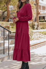 Woman wearing burgundy tiered midi dress with drawstring waist, long sleeves and black ankle boots