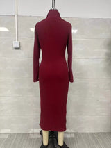 Woman wearing a burgundy ribbed knit V-neck long sleeve sweater dress styled with a black belt and tall brown Western boots.