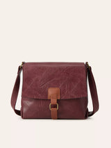 Burgundy vintage-style crossbody bag featuring a flap closure, decorative buckle detail, and adjustable shoulder strap.