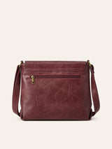 Burgundy vintage-style crossbody bag featuring a flap closure, decorative buckle detail, and adjustable shoulder strap.