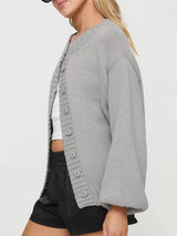 Women's gray button-down knit cardigan featuring a ribbed crew neckline, long sleeves, and relaxed fit. Cozy boutique sweater perfect for layering with jeans, dresses, or casual fall outfits.