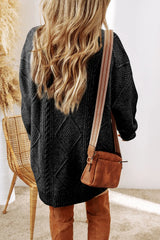 Woman wearing a black cable knit long sleeve sweater dress styled with knee-high brown boots and layered gold necklaces.