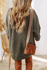Woman wearing a sage green cable knit long sleeve sweater dress styled with knee-high brown boots and layered gold necklaces.