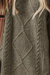 Woman wearing a sage green cable knit long sleeve sweater dress styled with knee-high brown boots and layered gold necklaces.