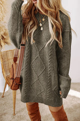 Woman wearing a sage green cable knit long sleeve sweater dress styled with knee-high brown boots and layered gold necklaces.