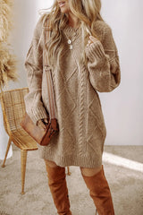 Woman wearing a tan cable knit long sleeve sweater dress styled with knee-high brown boots and layered gold necklaces.