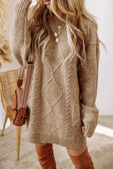 Woman wearing a tan cable knit long sleeve sweater dress styled with knee-high brown boots and layered gold necklaces.