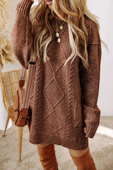 Woman wearing a taupe cable knit long sleeve sweater dress styled with knee-high brown boots and layered gold necklaces.