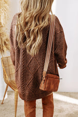 Woman wearing a taupe cable knit long sleeve sweater dress styled with knee-high brown boots and layered gold necklaces.