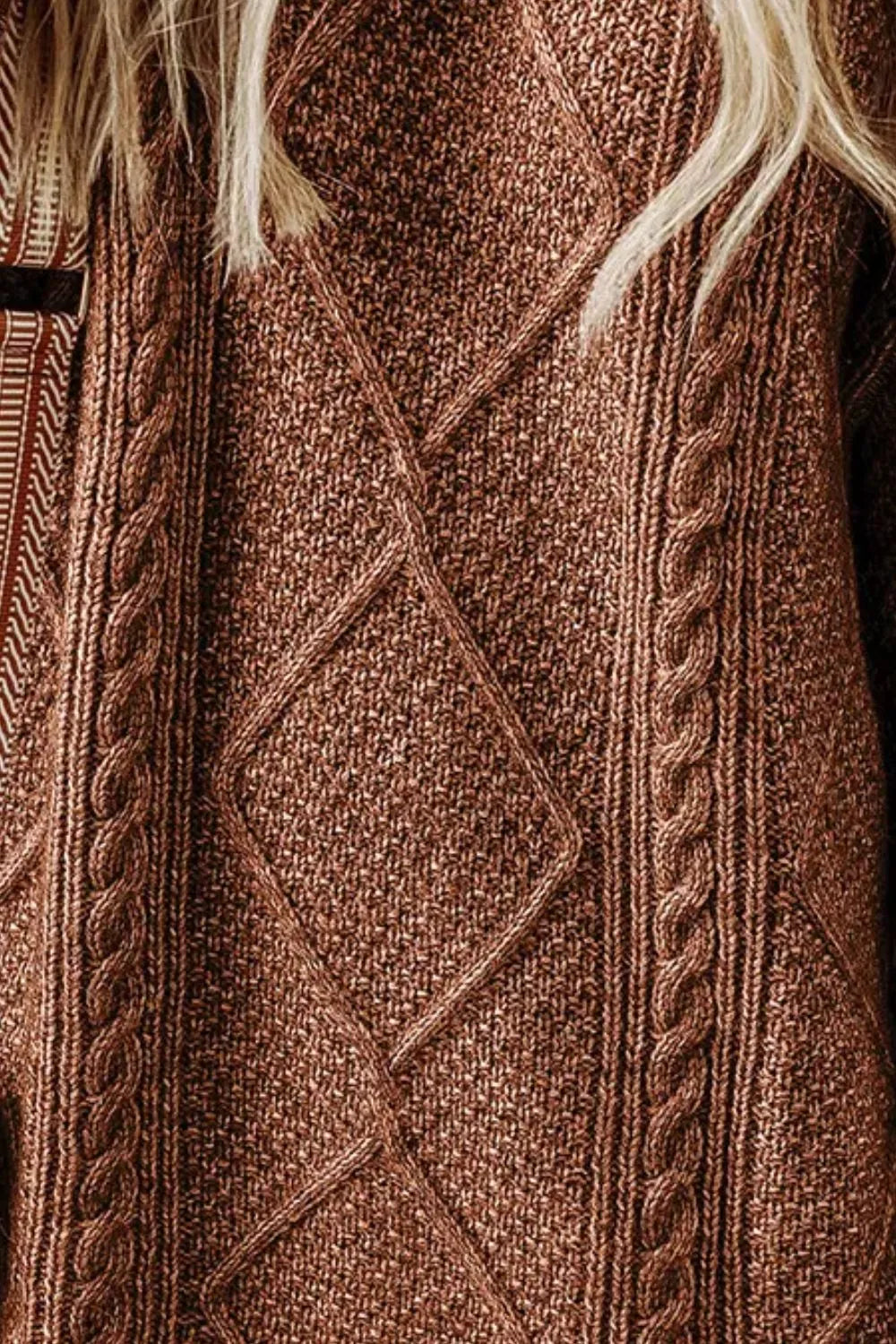 Woman wearing a taupe cable knit long sleeve sweater dress styled with knee-high brown boots and layered gold necklaces.