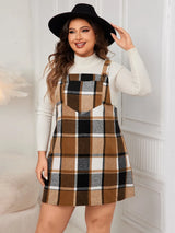 Woman wearing the Honey Plus Size Plaid Wide Strap Overall Dress layered over a cream mock neck sweater with a black felt hat, stylish plus size plaid fall dress from Chic Mystik Boutique.