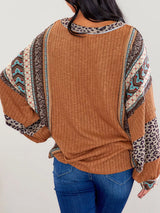 Women's caramel ribbed long sleeve top with leopard and Southwestern-inspired color block prints styled with blue jeans.