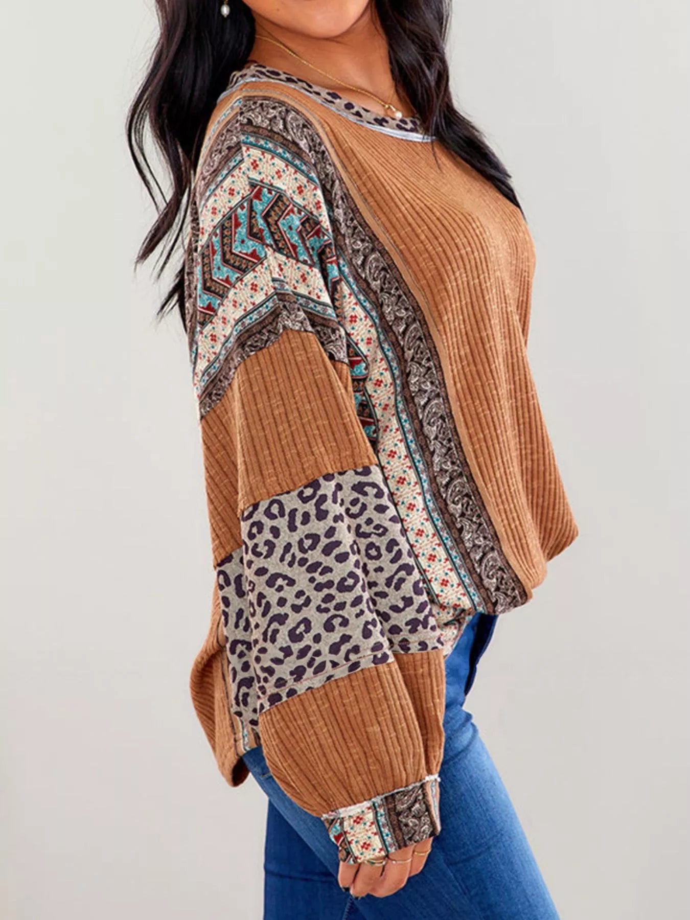 Women's caramel ribbed long sleeve top with leopard and Southwestern-inspired color block prints styled with blue jeans.