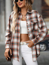 Woman wearing a caramel plaid oversized button-up shirt layered over a white top with white jeans and brown crossbody bag.