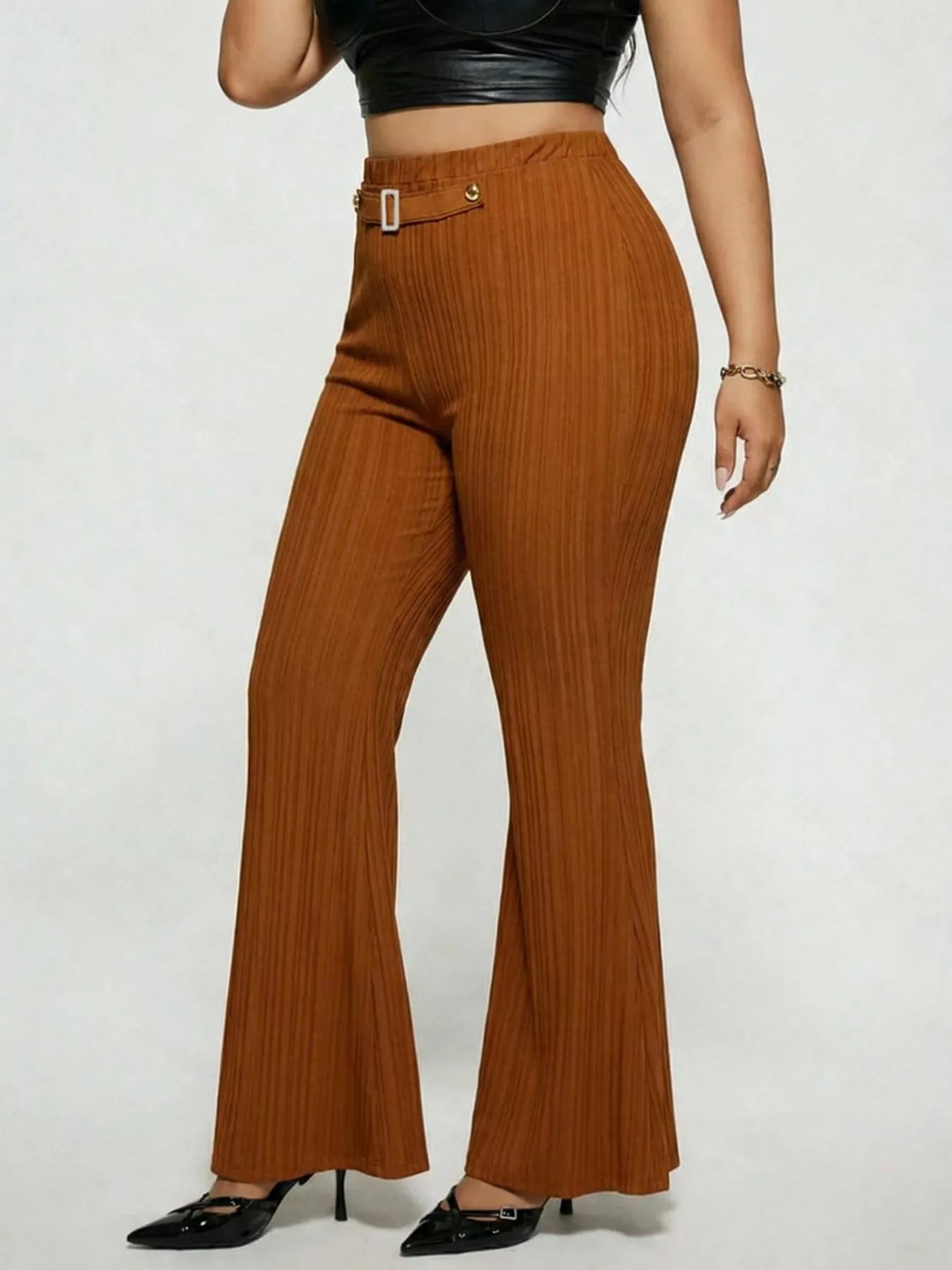 Model wearing caramel plus-size high-waisted flare pants styled with pointed-toe heels for an elegant and sophisticated look.