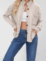Women's casual knit button-down cardigan in ivory featuring a stand collar, chest pocket, front pockets, and ribbed trim. Cozy boutique sweater perfect for layering with jeans and fall outfits.