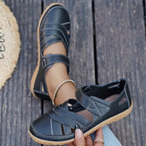 Pair of black sandals on a wooden floor