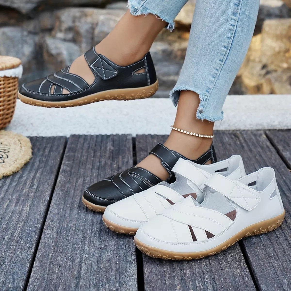 Black and white shoes on a wooden floor with a stone wall background