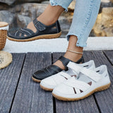 Black and white shoes on a wooden floor with a stone wall background