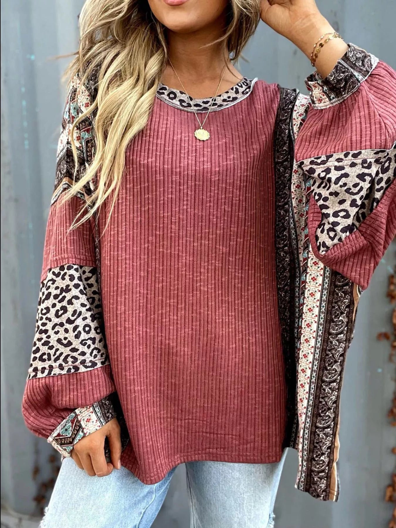 Women's cerise ribbed long sleeve top with leopard and Southwestern-inspired color block prints styled with blue jeans.