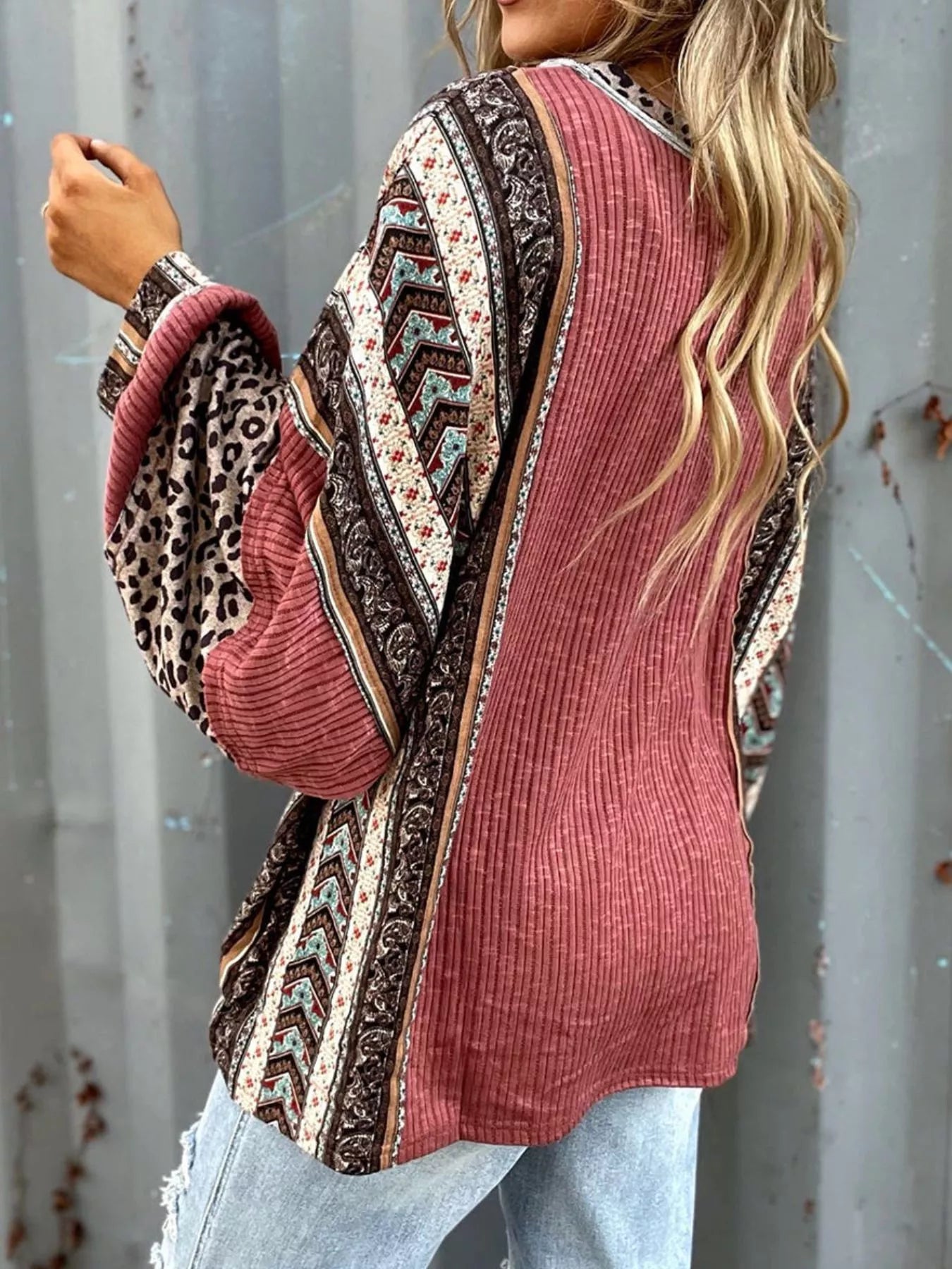 Women's cerise ribbed long sleeve top with leopard and Southwestern-inspired color block prints styled with blue jeans.