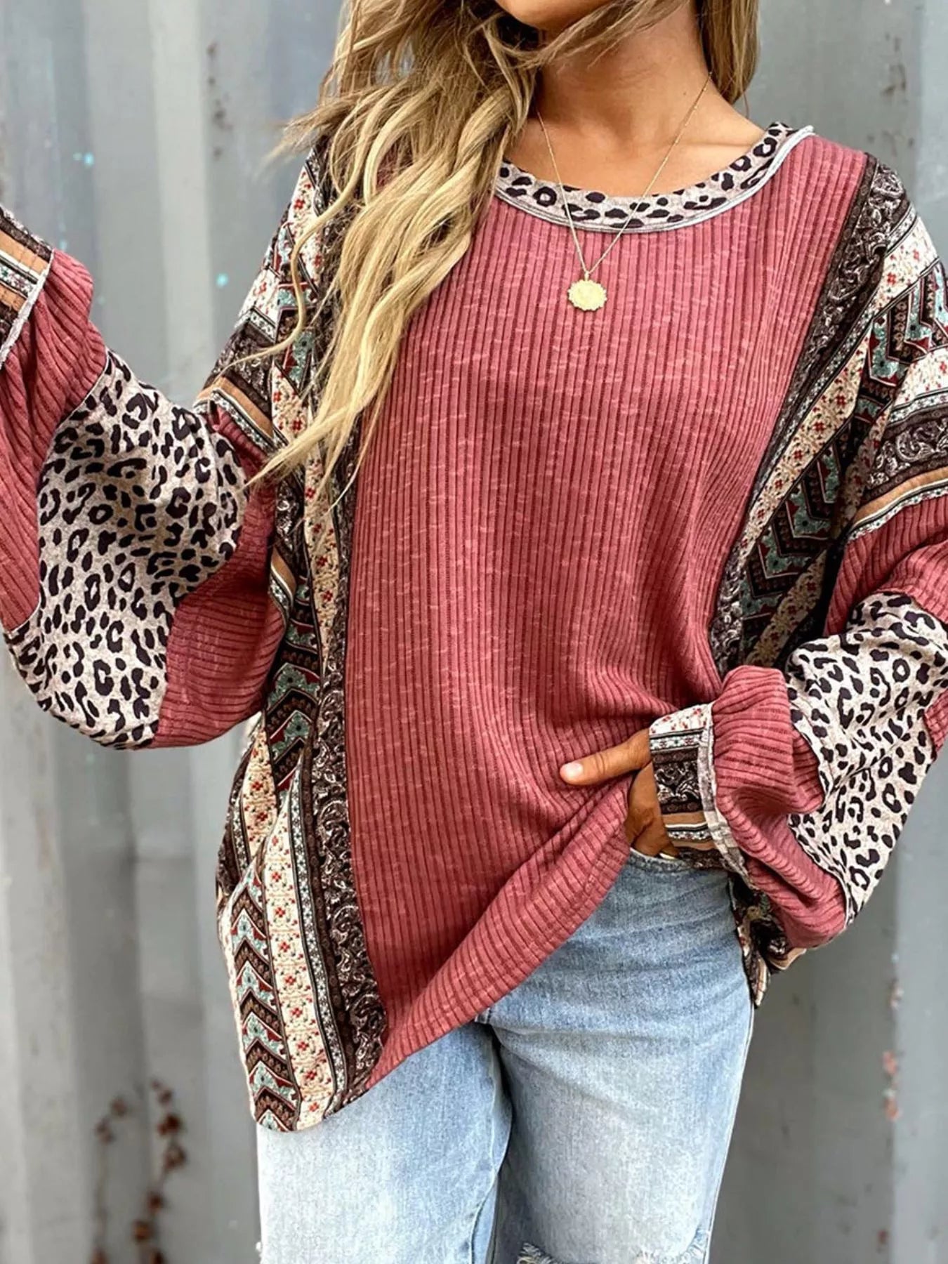 Women's cerise ribbed long sleeve top with leopard and Southwestern-inspired color block prints styled with blue jeans.