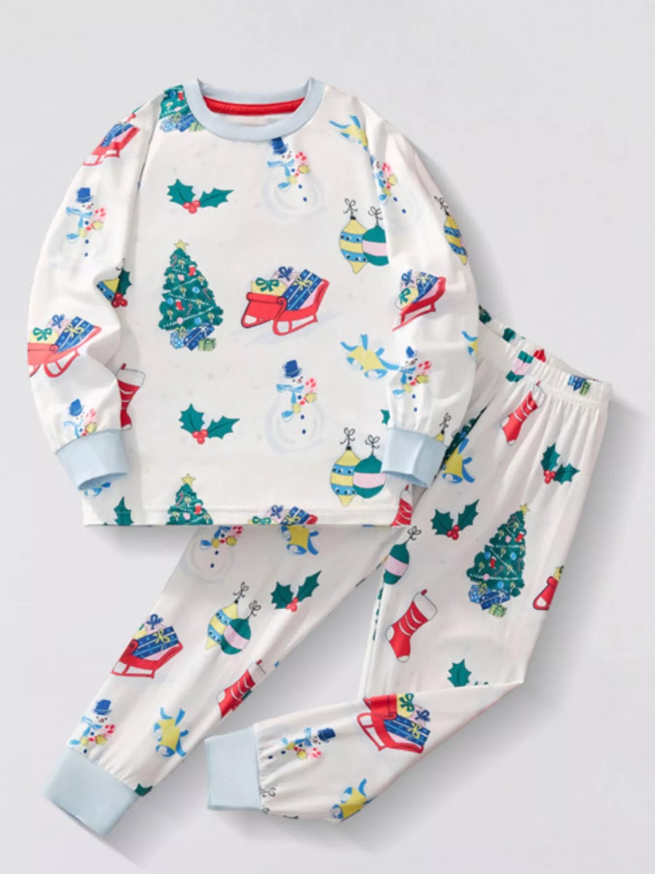Children's white Christmas two-piece top and pants set with colorful snowmen, Christmas trees, stockings, ornaments, sleighs, and light blue cuffs.