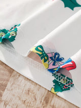 Children's white Christmas two-piece top and pants set with colorful snowmen, Christmas trees, stockings, ornaments, sleighs, and light blue cuffs.