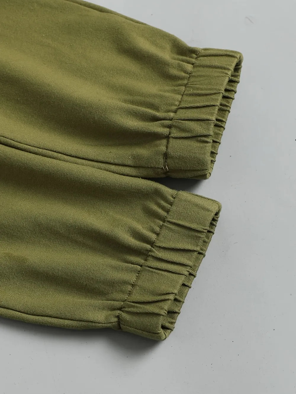 Children's olive green, cream, and beige color block long sleeve top with front chest pocket and matching olive-green pants, two-piece cotton blend outfit.