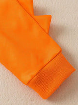 Children's white hooded sweatshirt with large orange dinosaur graphic and matching bright orange jogger-style pants.