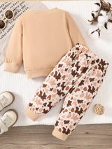 Children's two-piece farm animal outfit featuring a beige long-sleeve sweatshirt with embroidered cows and coordinating brown and cream cow-print drawstring pants.
