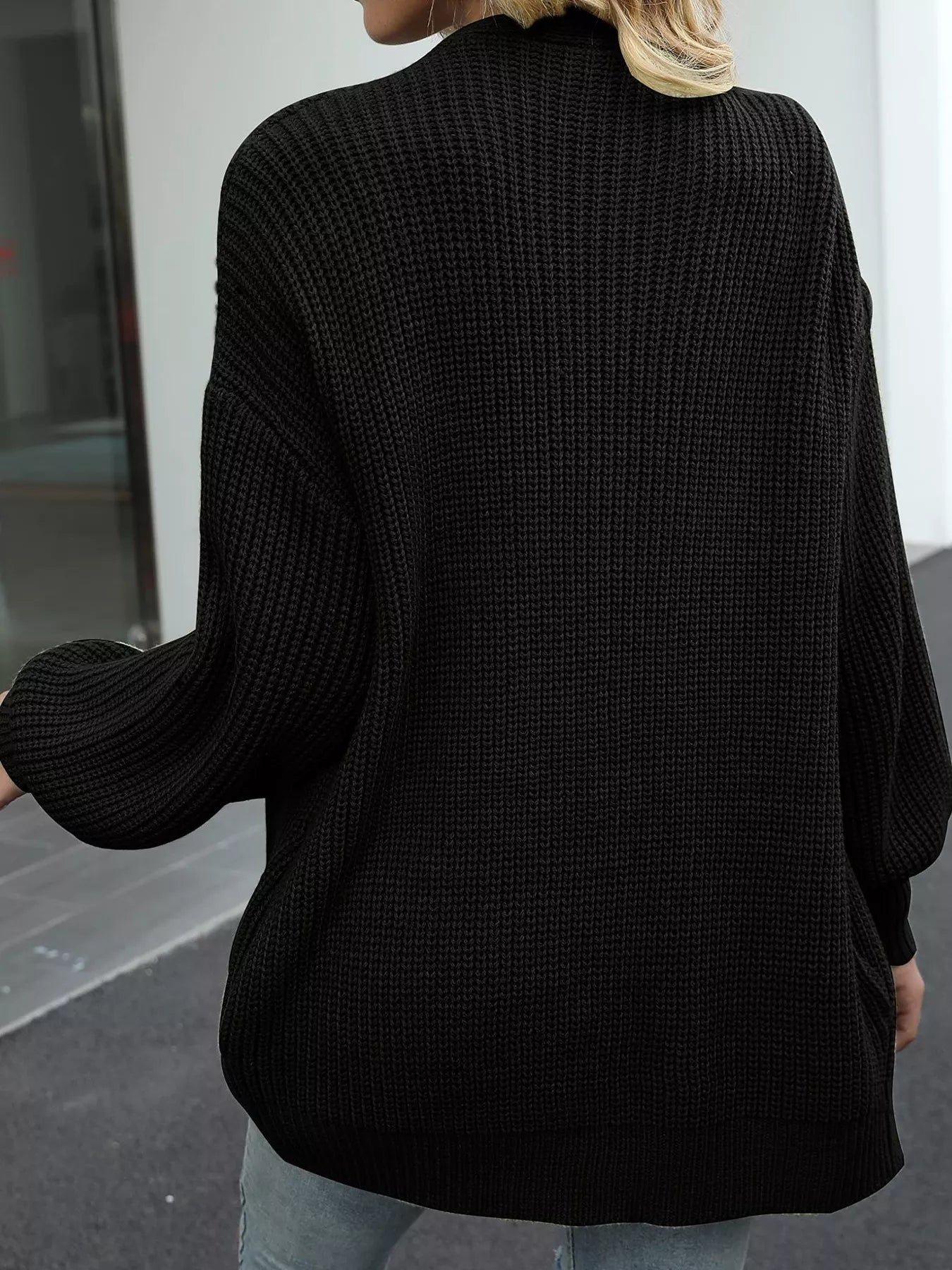 Women's oversized black chunky knit open front cardigan with long balloon sleeves, soft textured sweater perfect for fall layering with jeans.