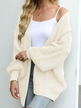 Women's oversized beige chunky knit open front cardigan with long balloon sleeves, soft textured sweater perfect for fall layering with jeans.