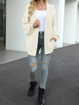 Women's oversized beige chunky knit open front cardigan with long balloon sleeves, soft textured sweater perfect for fall layering with jeans.