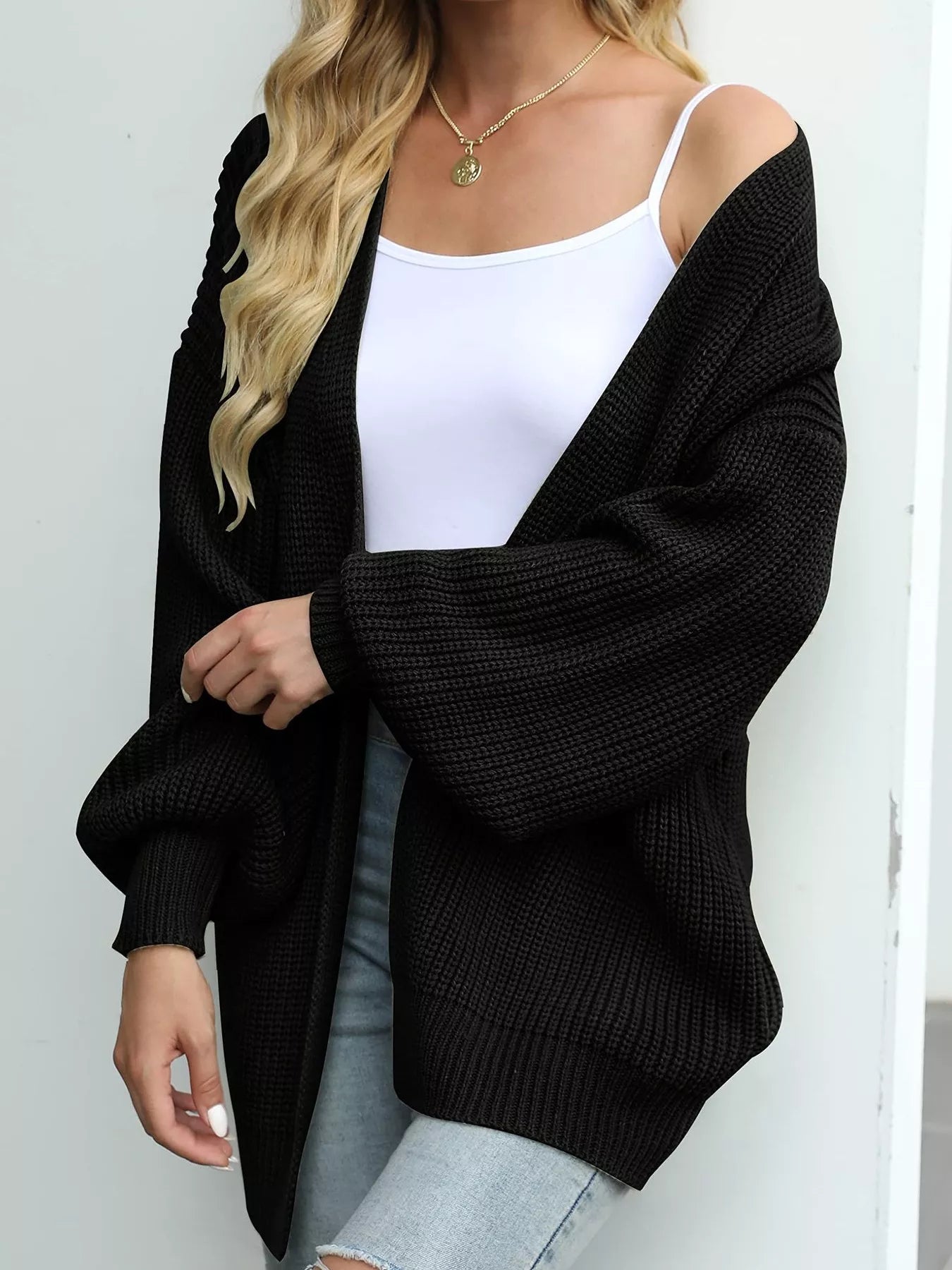 Women's oversized black chunky knit open front cardigan with long balloon sleeves, soft textured sweater perfect for fall layering with jeans.