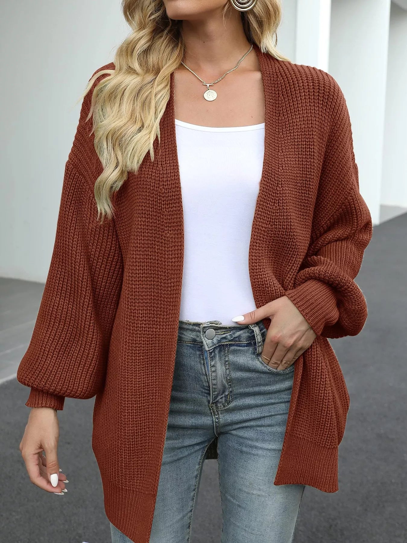Women's oversized brown chunky knit open front cardigan with long balloon sleeves, soft textured sweater perfect for fall layering with jeans.