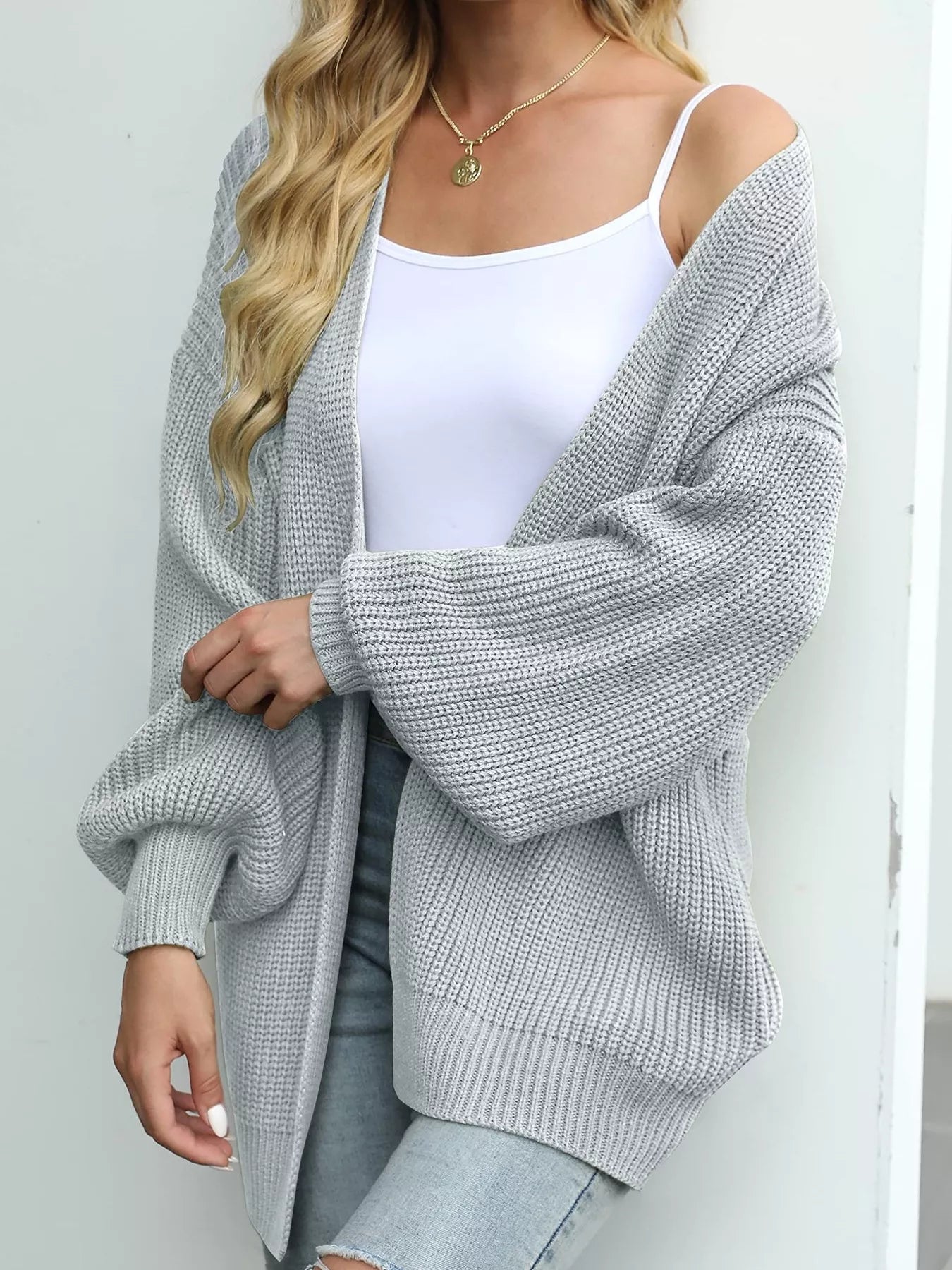 Women's oversized light gray chunky knit open front cardigan with long balloon sleeves, soft textured sweater perfect for fall layering with jeans.