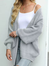 Women's oversized light gray chunky knit open front cardigan with long balloon sleeves, soft textured sweater perfect for fall layering with jeans.