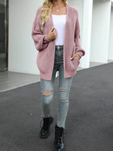 Women's oversized pink chunky knit open front cardigan with long balloon sleeves, soft textured sweater perfect for fall layering with jeans.