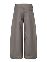 Men’s asymmetrical button wide-leg pants in coffee and black with pleated front and statement button detail.