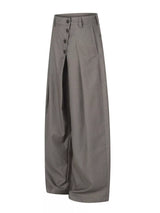 Men’s asymmetrical button wide-leg pants in coffee and black with pleated front and statement button detail.