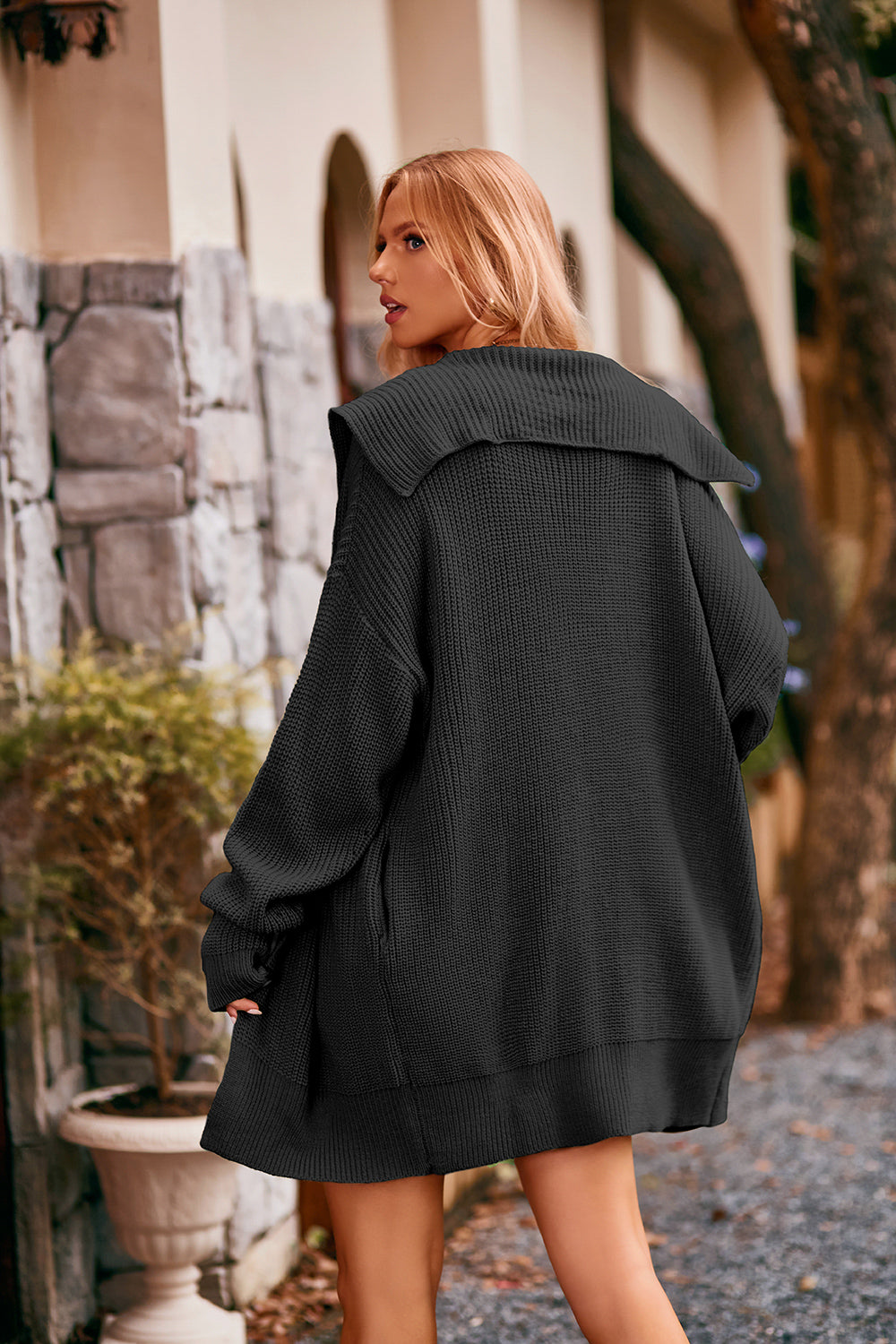 Women's black collared neck button-up cardigan with front pockets, oversized knit sweater layered over a black tank and denim shorts for stylish fall fashion.