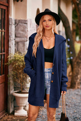 Women's navy collared neck button-up cardigan with front pockets, oversized knit sweater layered over a black tank and denim shorts for stylish fall fashion.