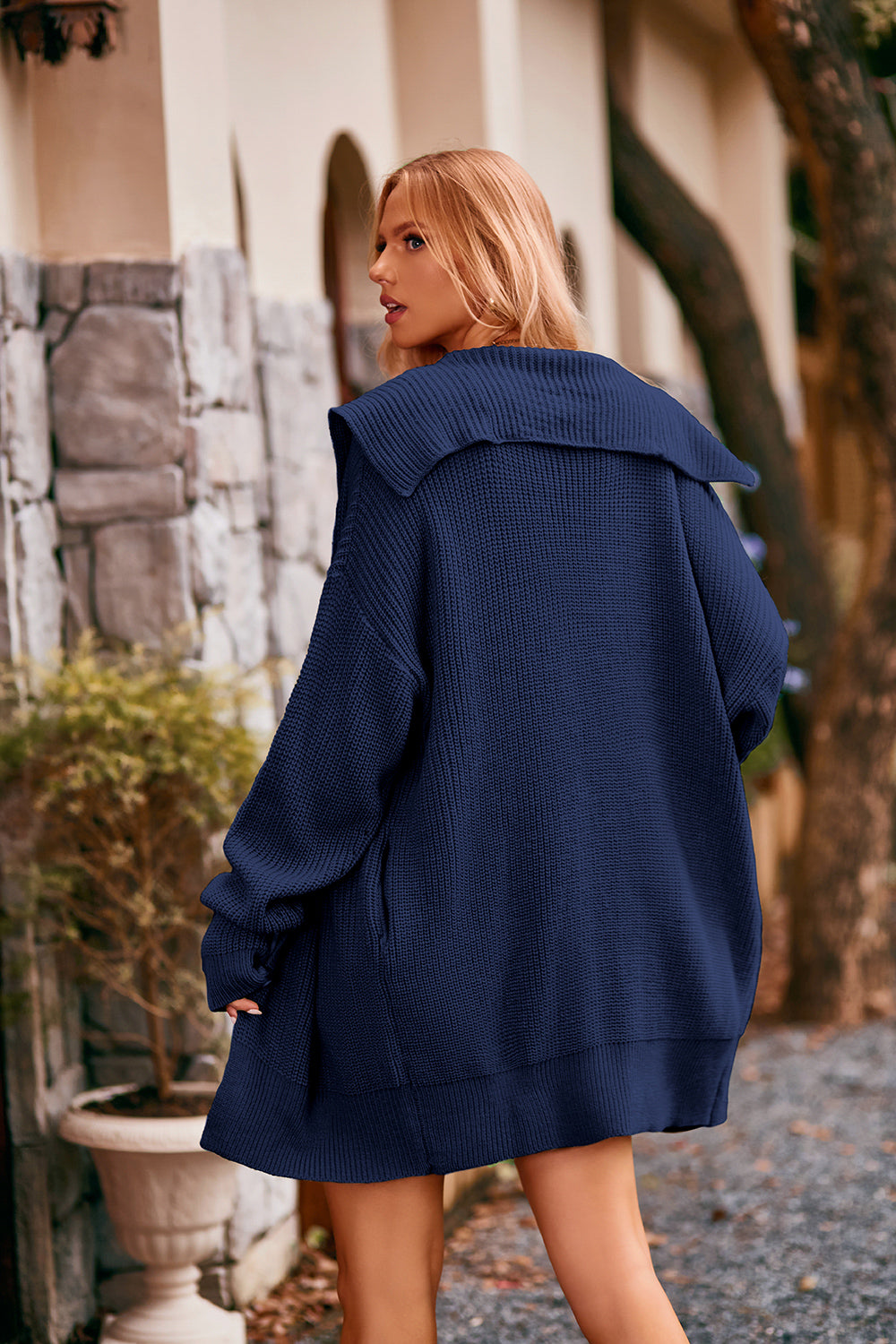 Women's navy collared neck button-up cardigan with front pockets, oversized knit sweater layered over a black tank and denim shorts for stylish fall fashion.