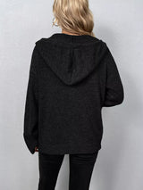 Women's black cozy knit hooded button-down cardigan with black buttons, soft lightweight sweater paired with black pants for casual fall style.