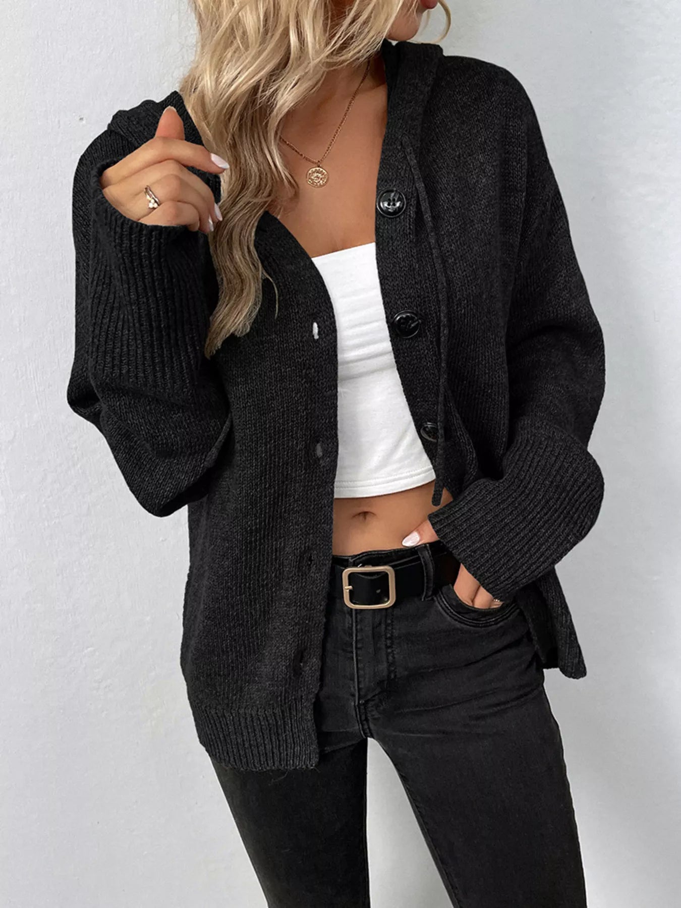 Women's black cozy knit hooded button-down cardigan with black buttons, soft lightweight sweater paired with black pants for casual fall style.
