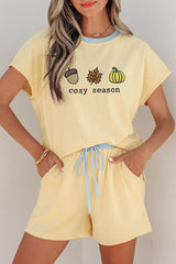 Woman wearing a Cozy Season embroidered ribbed two-piece short set featuring a relaxed fit, drawstring shorts, and fall-inspired embroidered graphics.