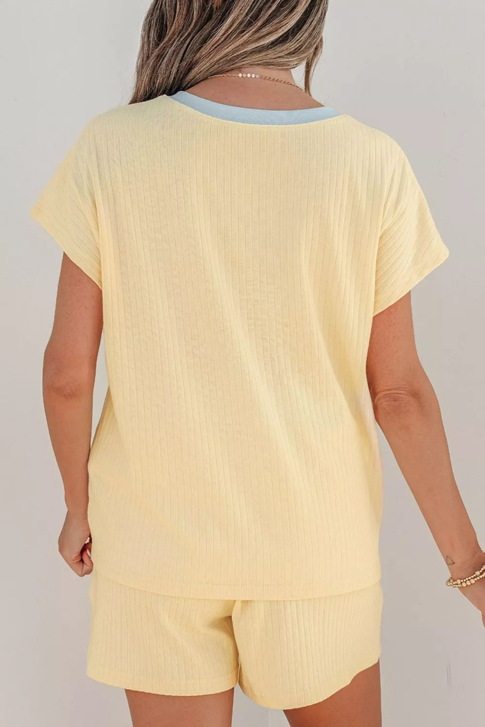 Woman wearing a Cozy Season embroidered ribbed two-piece short set featuring a relaxed fit, drawstring shorts, and fall-inspired embroidered graphics.