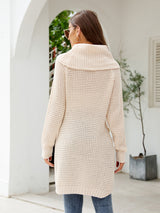 Woman wearing a cream turtleneck waffle-knit slit sweater dress with long sleeves and a relaxed fit for fall.
